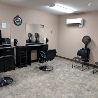 A tidy and organized hair salon with styling stations and a small waiting area.