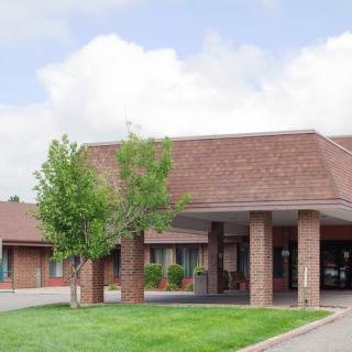A hotel building with a landscaped entrance and trees.