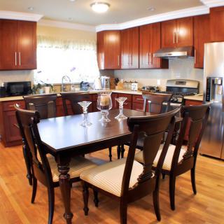 A modern kitchen with wooden cabinets and a dining table set.