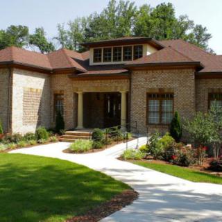 A beautiful brick house with a well-maintained garden and curved pathway.
