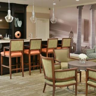 A modern lounge area featuring a bar with high stools and comfortable seating.