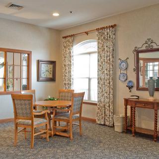 A cozy living room with a round table and chairs, featuring elegant curtains and decor.