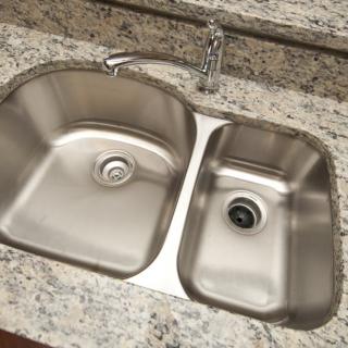 A dual-basin stainless steel kitchen sink set in a granite countertop.