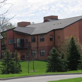A residential building surrounded by trees and grass.