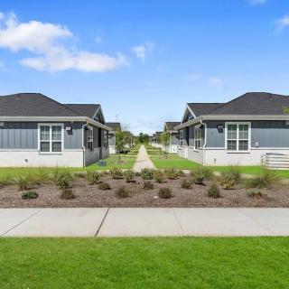 A suburban neighborhood with two modern houses and a landscaped walkway.
