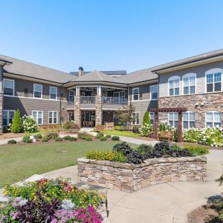 A beautifully landscaped residential courtyard with a modern building in the background.