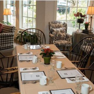 A cozy dining space with a neatly set table and comfortable seating.