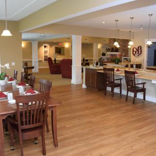 A spacious open floor plan featuring a kitchen and dining area with wood flooring and modern decor.