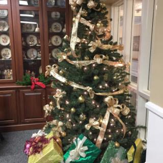 A beautifully decorated Christmas tree surrounded by colorful gifts, adding a festive touch to the room.