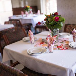 A beautifully set dining table with floral decorations in a restaurant.