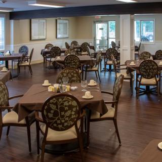 An empty dining room with elegantly set tables and chairs.