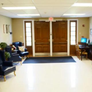 A well-lit lobby area with seating and a computer desk.
