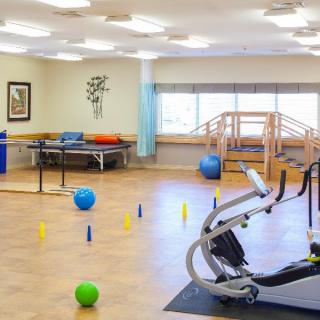 A rehabilitation gym equipped with various exercise machines and therapy tools.