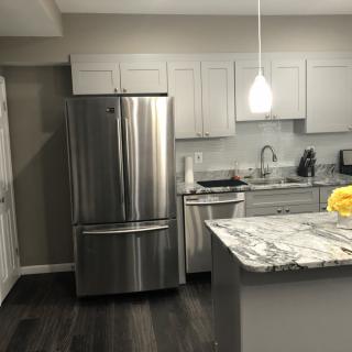 A modern kitchen with stainless steel appliances and marble countertops.