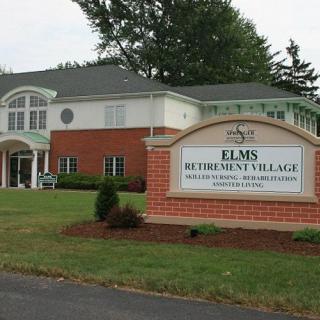 A view of the Elms Bethlehem Village facility with its entrance and sign in the foreground.
