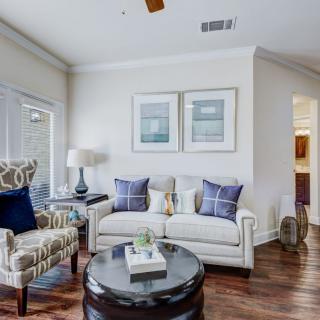 A cozy living room with a white sofa, accent chairs, and a round coffee table.