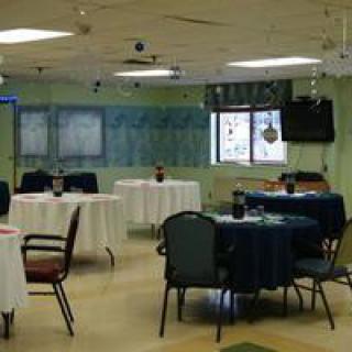 A well-lit dining room with decorated tables and chairs arranged neatly.