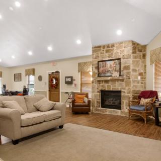 A cozy living room with a stone fireplace and comfortable seating.