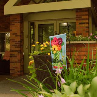 A welcoming entrance surrounded by vibrant flowers and greenery.