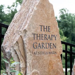 A beautifully crafted stone sign for 'The Therapy Garden' at Aetheria Manor.