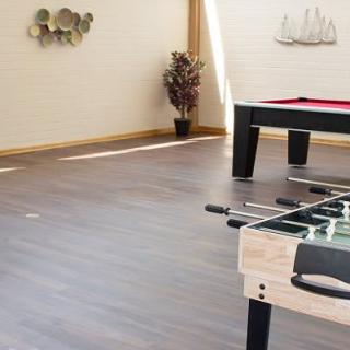 A spacious game room with a foosball and pool table.