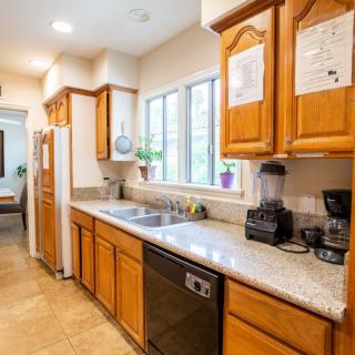 A bright kitchen interior with wooden cabinets and modern appliances.