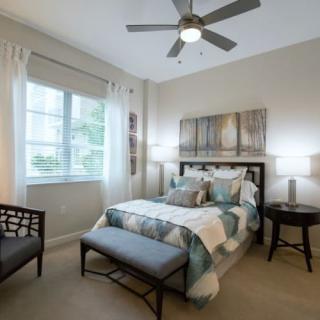 A modern, well-lit bedroom featuring stylish decor and comfortable furnishings.