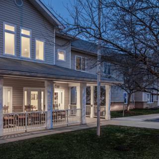 A well-lit residential house during the evening with visible exterior details.
