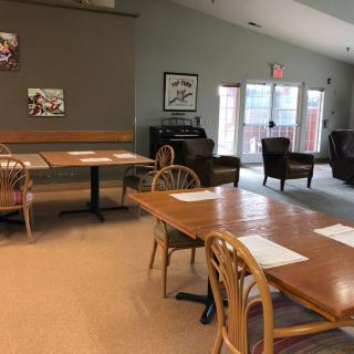 An empty cafe dining area with tables and chairs, featuring a cozy interior design.