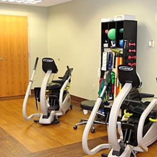 A small fitness room equipped with exercise machines and various workout accessories.