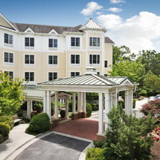 A hotel with a grand entrance surrounded by lush greenery.