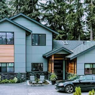 A contemporary home nestled among tall trees, showcasing a blend of modern design and natural surroundings.