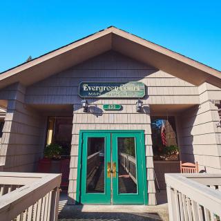 The entrance of the Evergreen Inn with green double doors and a wooden exterior.