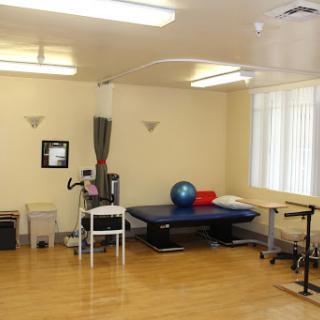 A spacious physical therapy room equipped with various exercise tools for rehabilitation.