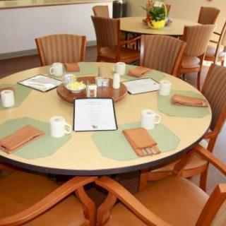A neatly set dining table with menus and cups in a restaurant.