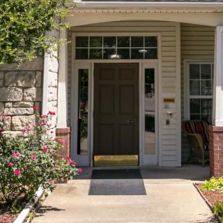 A welcoming front entrance of a house surrounded by well-maintained landscaping.