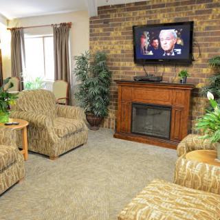 A cozy living room featuring comfortable seating, a television for entertainment, and decorative plants.