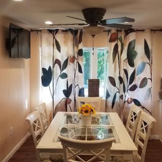 A cozy dining room with a table, chairs, and floral curtains.