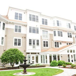 A multi-story residential building with a landscaped courtyard and a fountain.