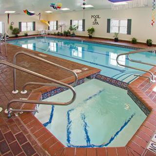 An inviting indoor swimming pool with an adjacent hot tub.