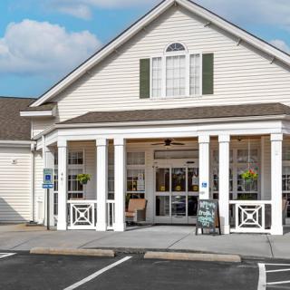 A small storefront with a gabled roof and a parking area in front.