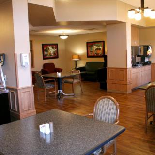 A cozy hotel lobby with seating and a coffee station.