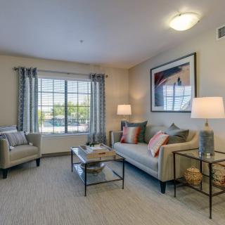 A cozy living room with a sofa, armchair, and stylish decor.