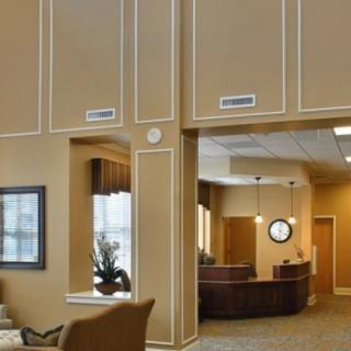A modern office reception area featuring a seating arrangement and a front desk.