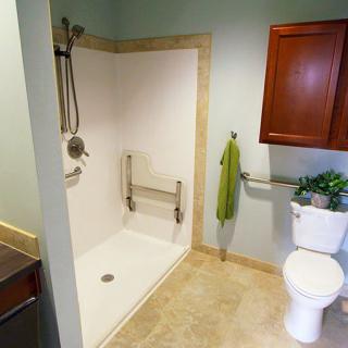 A modern accessible bathroom with a walk-in shower and grab bars.