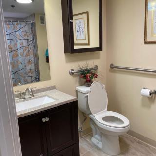 A neatly arranged modern bathroom with a toilet, sink, and wall art.