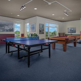 A spacious game room featuring a ping pong table and a pool table.