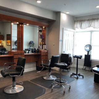 A modern hair salon interior with styling chairs and mirrors.