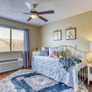 A cozy bedroom with a single bed, ceiling fan, and decorative elements.