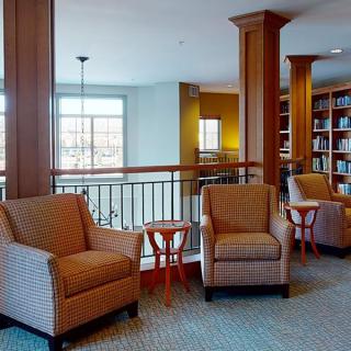 A cozy library interior with comfortable seating and wooden bookshelves.
